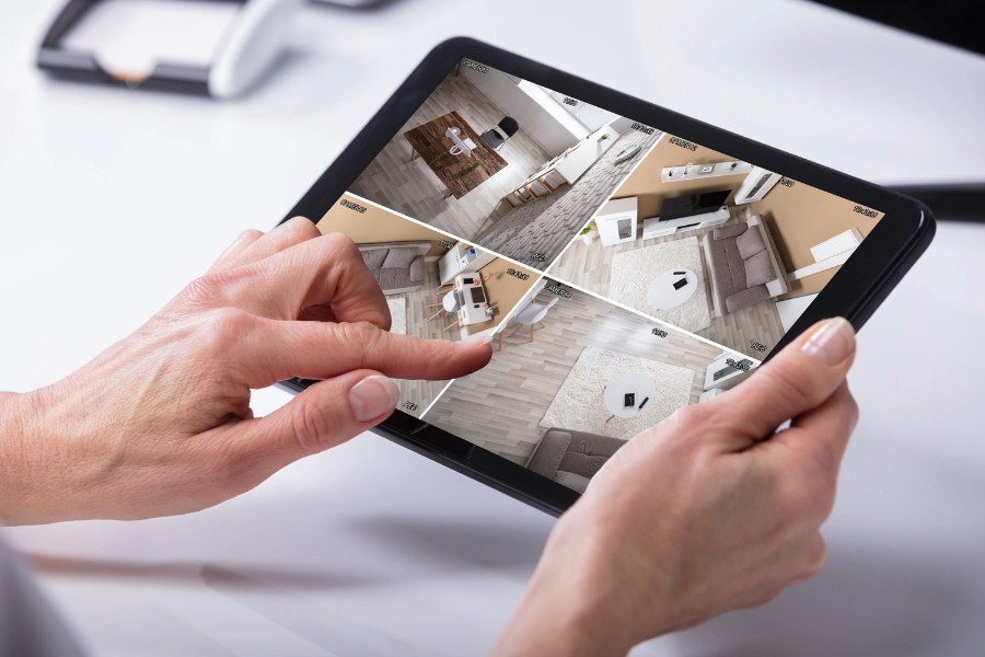 Individual holding a tablet featuring a surveillance system for safety and monitoring.